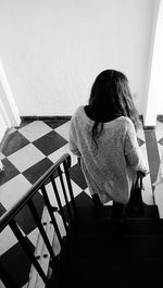 Rear view of woman standing on steps