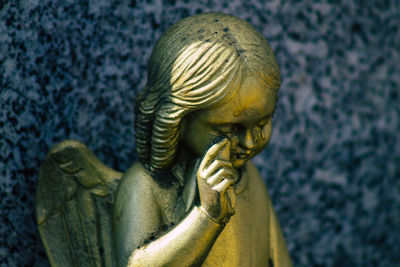 Close-up of angel statue against wall