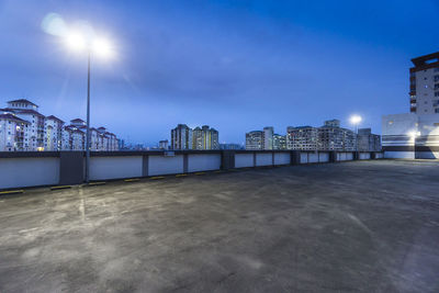 Illuminated buildings against cloudy sky