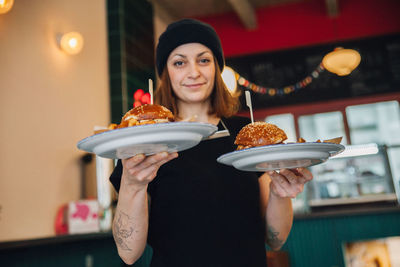 Portrait of young woman holding food