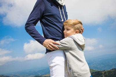 Rear view of father and son against sky