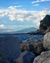 View of calm beach against cloudy sky