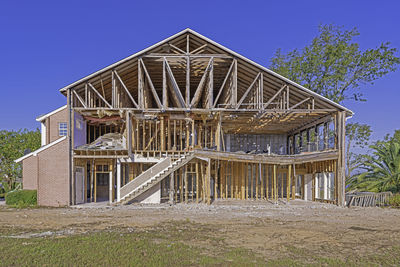 Low angle view of house on field against clear blue sky