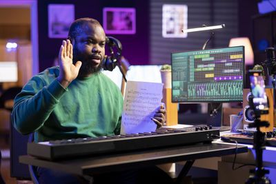 Side view of man using laptop at table
