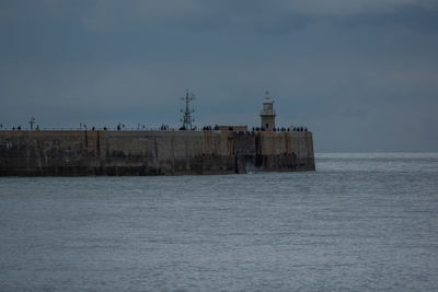 Building by sea against sky