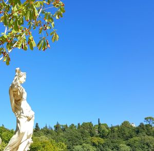 Low angle view of statue against clear blue sky