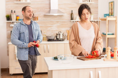 Mid adult woman standing at table at home