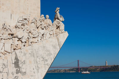 Statue of liberty in city against clear blue sky