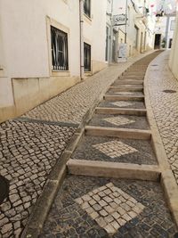 Empty alley amidst buildings in city