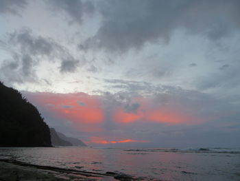 Scenic view of sea against dramatic sky during sunset