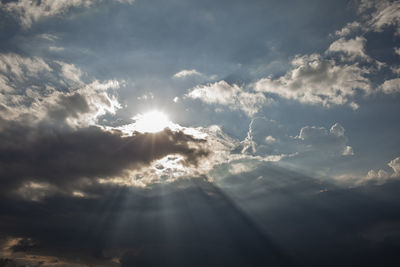 Moody cumulus clouds with sunbeams in the sky