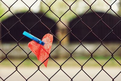 Close-up of heart shape on chainlink fence