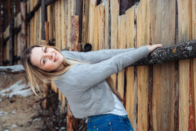 Young beautiful girl near wooden fence