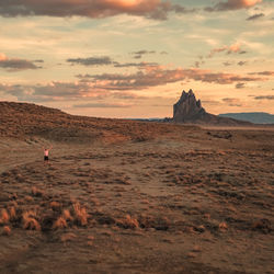 Rock formations on landscape against sky during sunset