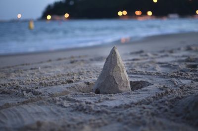 Surface level of sand on beach against sky during sunset