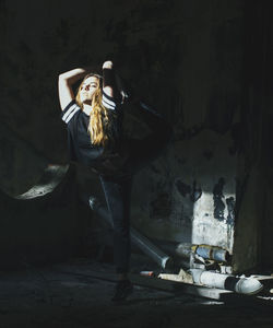 Woman stretching leg in darkroom
