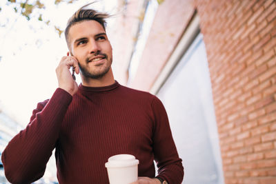 Young man using mobile phone outdoors