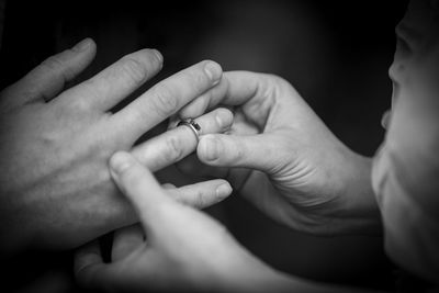 Cropped hands of couple exchanging ring