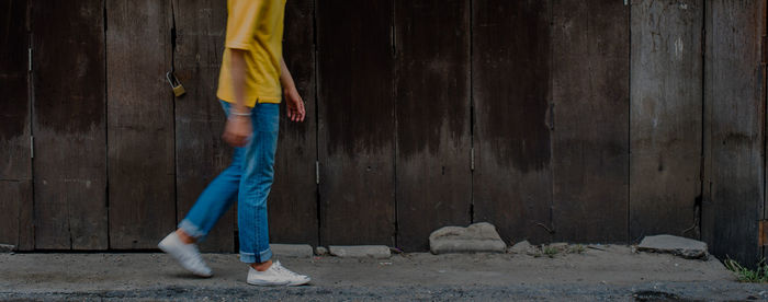 Low section of woman standing against wall