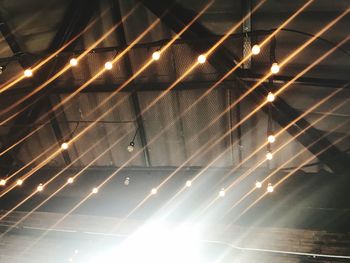 Low angle view of illuminated lights against sky at night