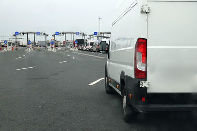 Vehicles on road against sky in city