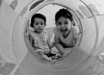 Portrait of cute sisters in tent