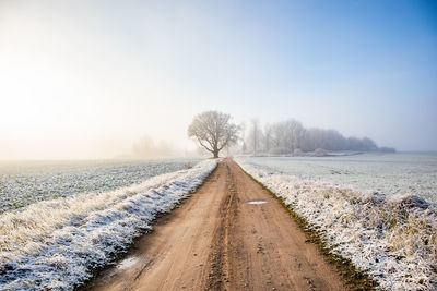 A beautiful scenery of a gravel road in the late autumn with first snow. northern europe landscape.