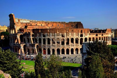 High angle view of coliseum against blue sky during sunny day