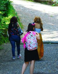 Rear view of women walking on road