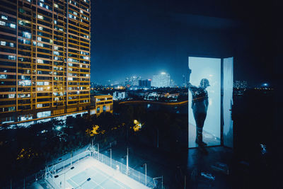 Digital composite image of illuminated modern buildings at night