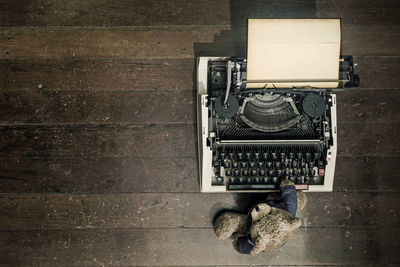High angle view of old typewriter and teddy bear on table