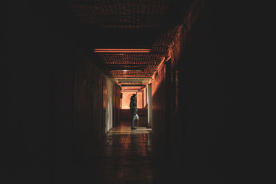 Side view of man standing in building corridor