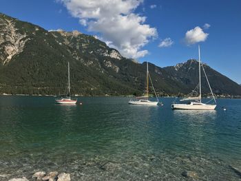 Sailboats in sea against sky