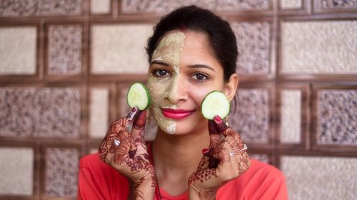 Portrait of young woman having food at home