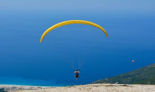 People paragliding against sea