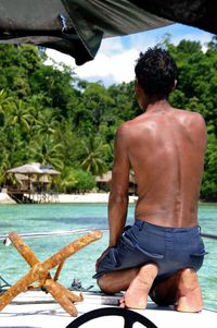 Rear view of two people sitting in water