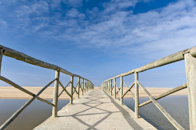 Railing by sea against sky