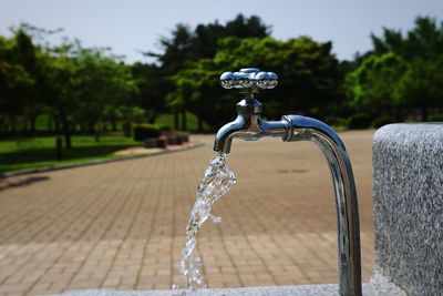 Close-up of water flowing from faucet in park