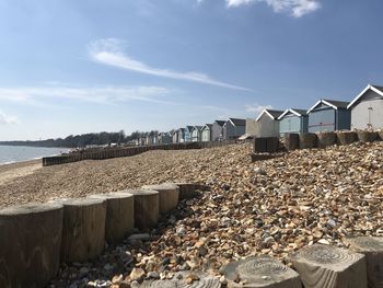 Beach huts by buildings against sky