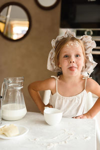 Little girl cooking pizza in the kitchen