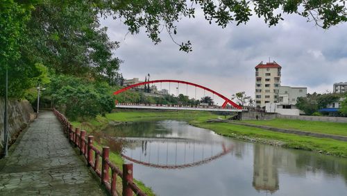 Bridge over river in city against sky