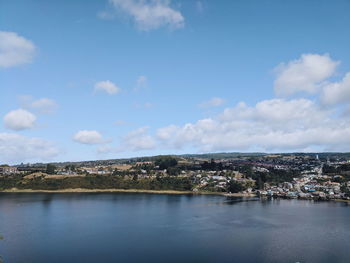 Aerial view of city by sea against sky