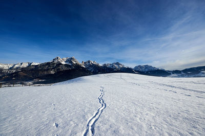 Scenic view of snowcapped mountains against blue sky