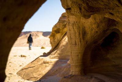 Rear view of man in cave