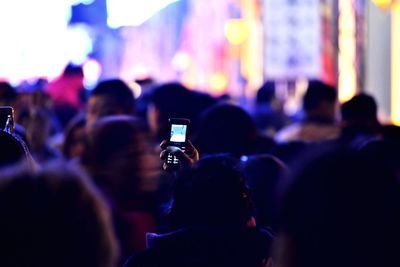 Rear view of people photographing at music concert