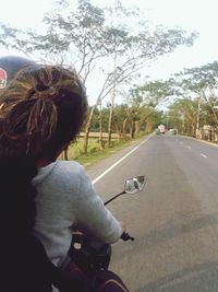 Woman riding motorcycle on road