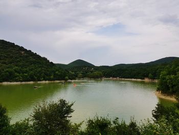 Scenic view of lake by trees against sky