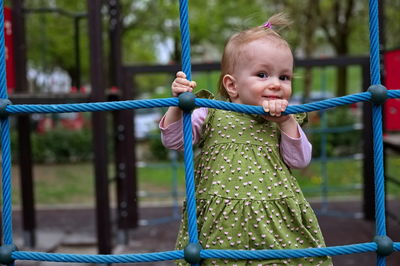 Portrait of boy standing on swing