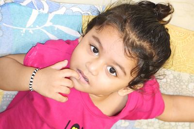Portrait of cute girl lying on bed