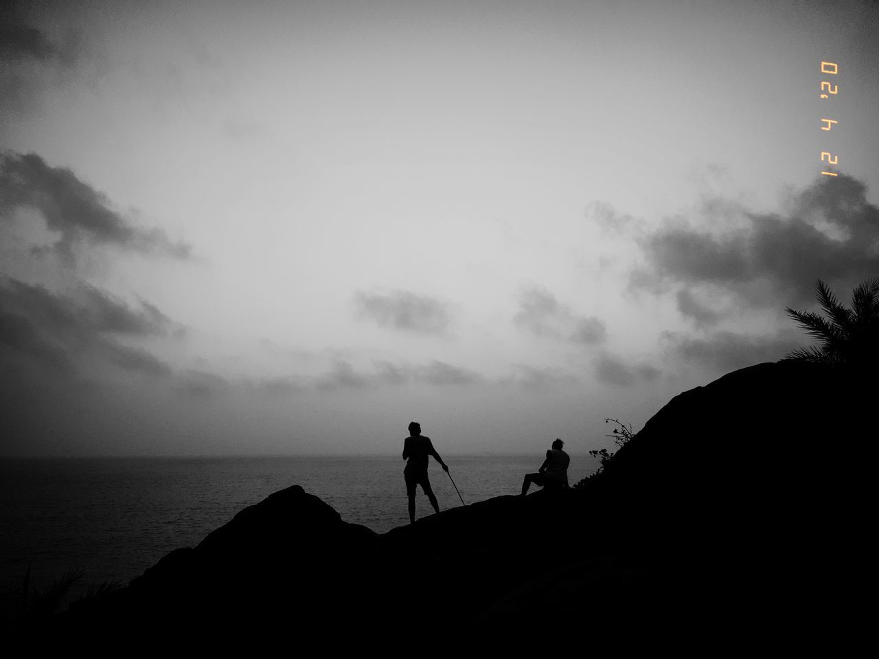 SILHOUETTE MEN STANDING AT BEACH AGAINST SKY